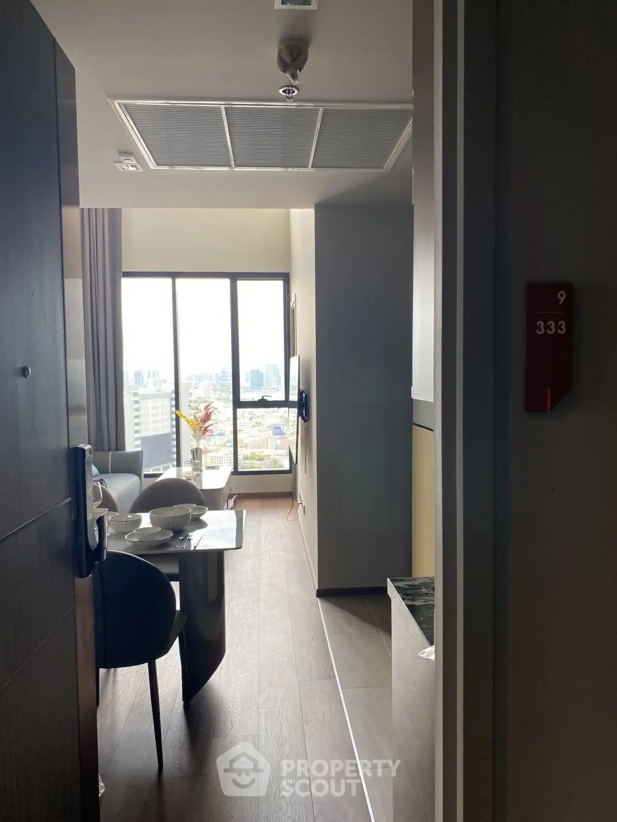 Modern apartment entrance with city view and dining area