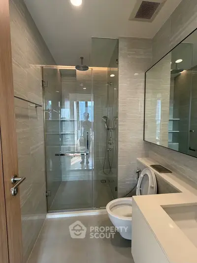 Modern bathroom with glass shower and sleek fixtures in a luxury apartment.