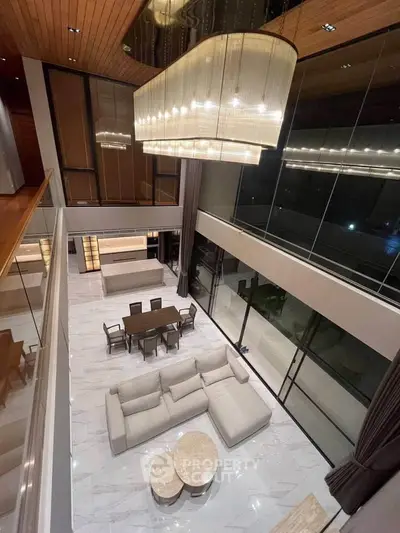Luxurious modern living room with high ceilings and elegant chandelier