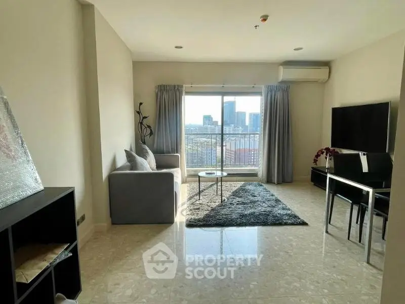 Spacious living room with city view, modern furniture, and natural light.