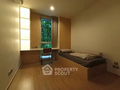 Cozy minimalist bedroom with wooden flooring and large window view
