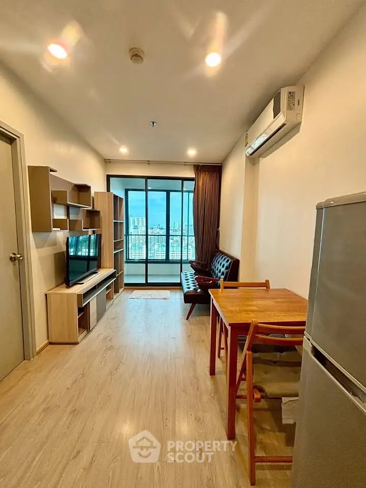 Modern living room with balcony view, stylish furniture, and air conditioning in a high-rise apartment.