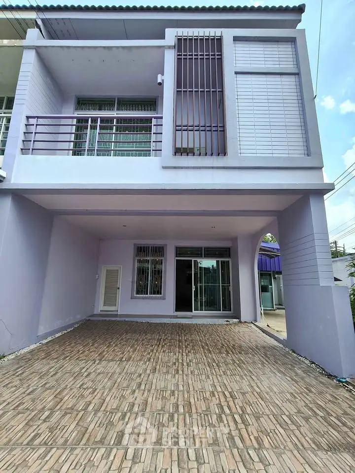 Modern two-story purple house with spacious driveway and large windows.