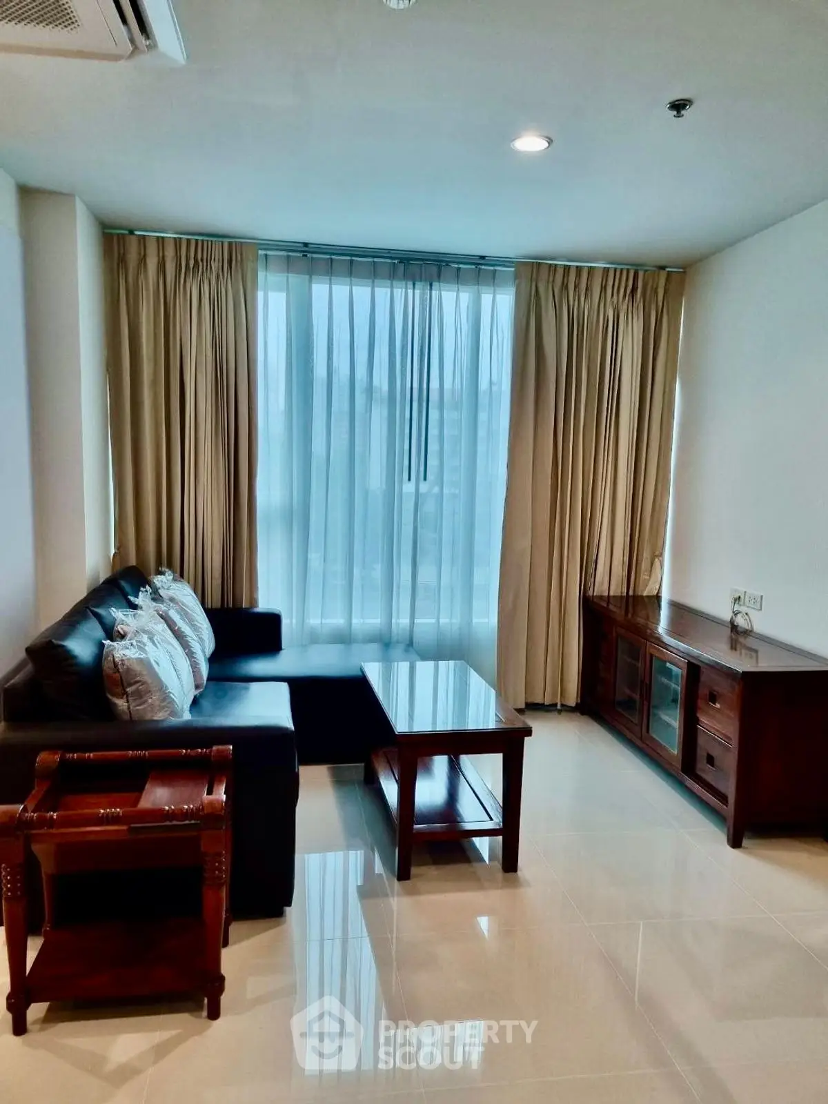 Spacious living room with modern furniture and large window for natural light.