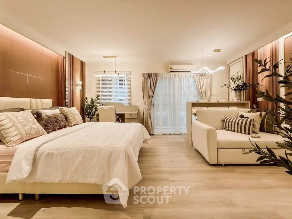 Luxurious open-plan bedroom and living area with modern decor and natural light.