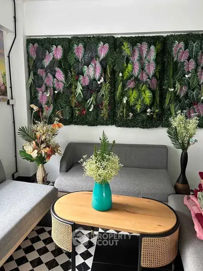 Chic living room with stylish grey sofas and vibrant plant wall decor