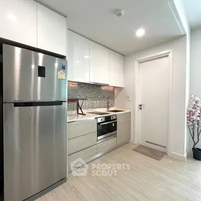 Modern kitchen with sleek appliances and stylish cabinetry in a contemporary apartment.