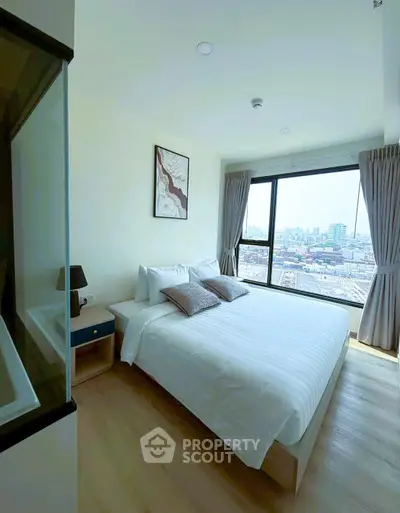 Bright and airy bedroom with city view, featuring modern decor and large windows for natural light.