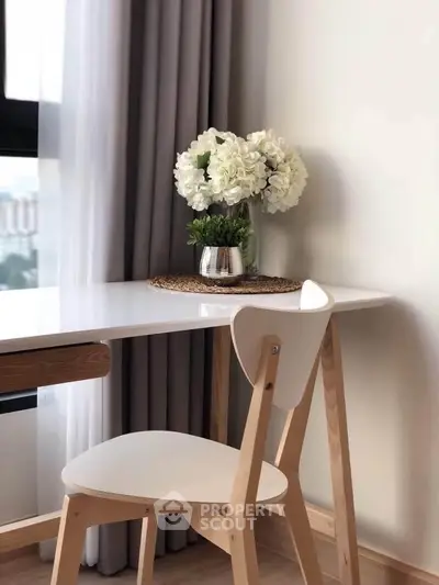 Elegant study nook with modern chair and floral decor by window