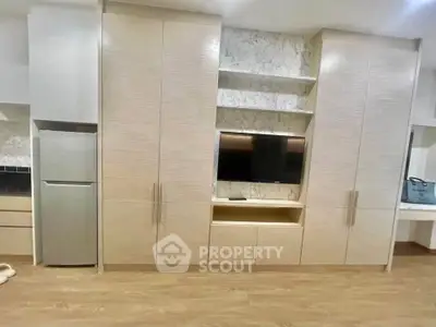 Modern living room with built-in storage and TV unit, featuring sleek cabinetry and elegant design.