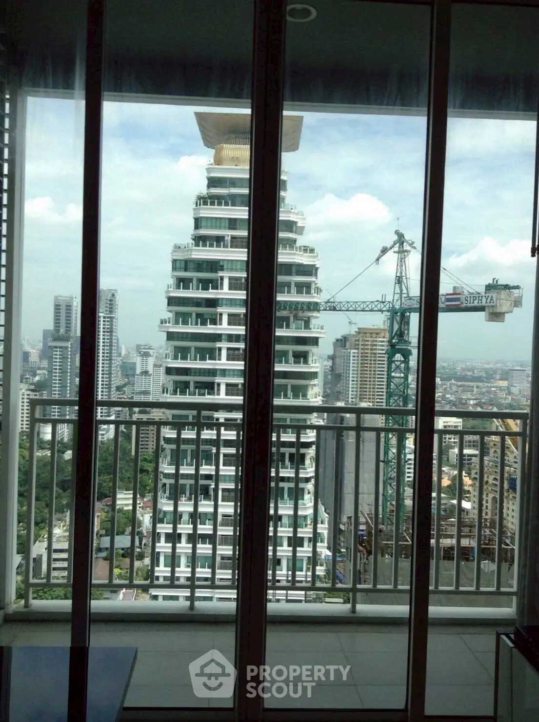 Stunning cityscape view from high-rise apartment balcony with modern architecture.