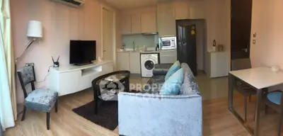 Modern living room with open kitchen, featuring sleek furniture and built-in appliances for stylish urban living.