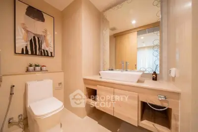 Modern bathroom with elegant fixtures and stylish decor, featuring a large mirror and contemporary artwork.