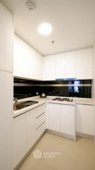 Modern white kitchen with sleek cabinets and gas stove