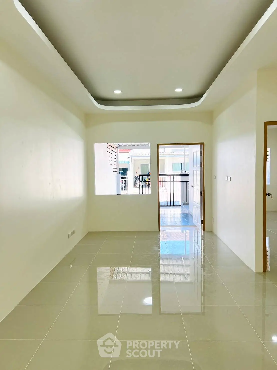 Spacious and bright interior with glossy tiled floors and modern ceiling design