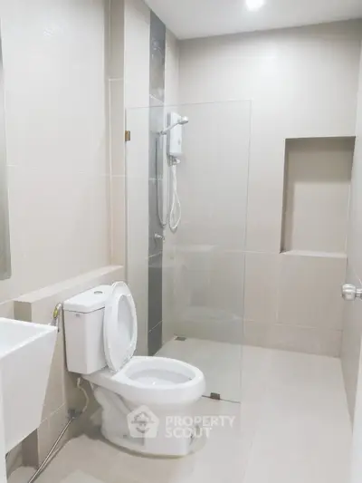 Modern bathroom with glass shower and sleek fixtures in a contemporary home.