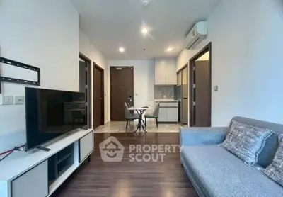 Modern living room with sleek furniture and open kitchen layout in a stylish apartment.