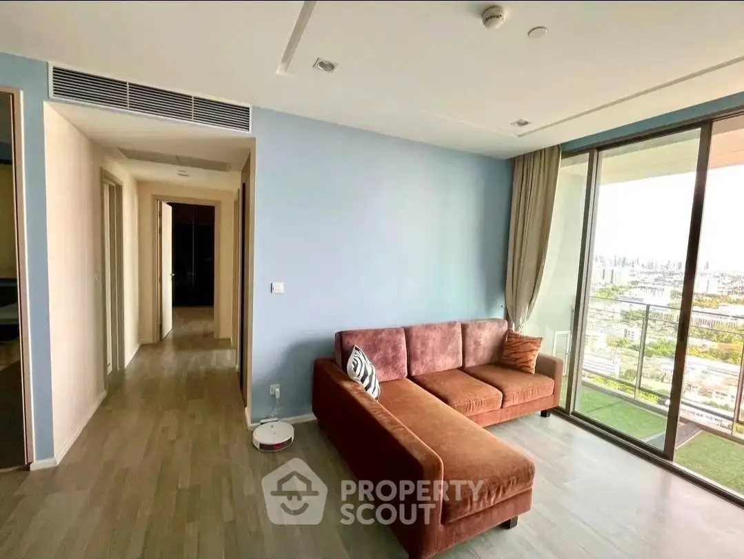Spacious living room with modern decor and stunning city view from large windows.