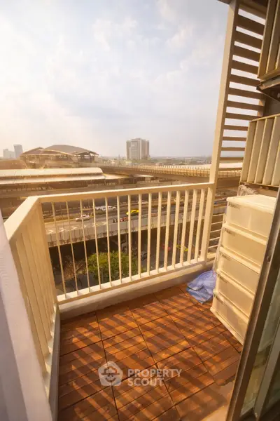 Charming balcony with city view and wooden flooring, perfect for relaxation and enjoying urban scenery.