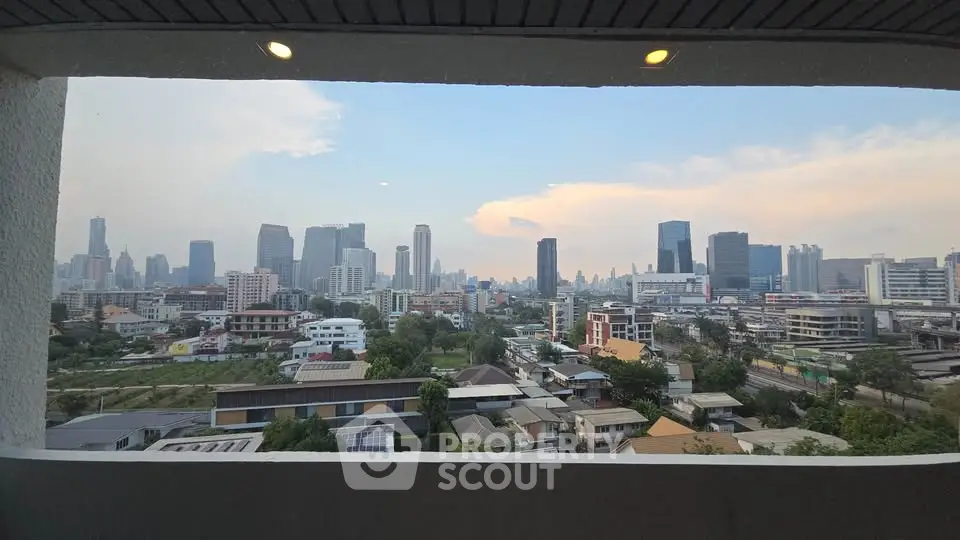 Stunning cityscape view from a high-rise balcony overlooking urban skyline at sunset.