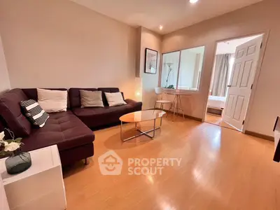 Spacious living room with modern decor and wooden flooring, featuring a cozy sofa and stylish coffee table.