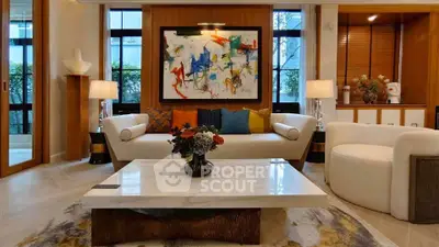 Luxurious living room with modern art, elegant furniture, and large windows for natural light.