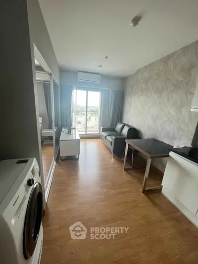 Modern living room with wooden flooring, stylish furniture, and a scenic balcony view.