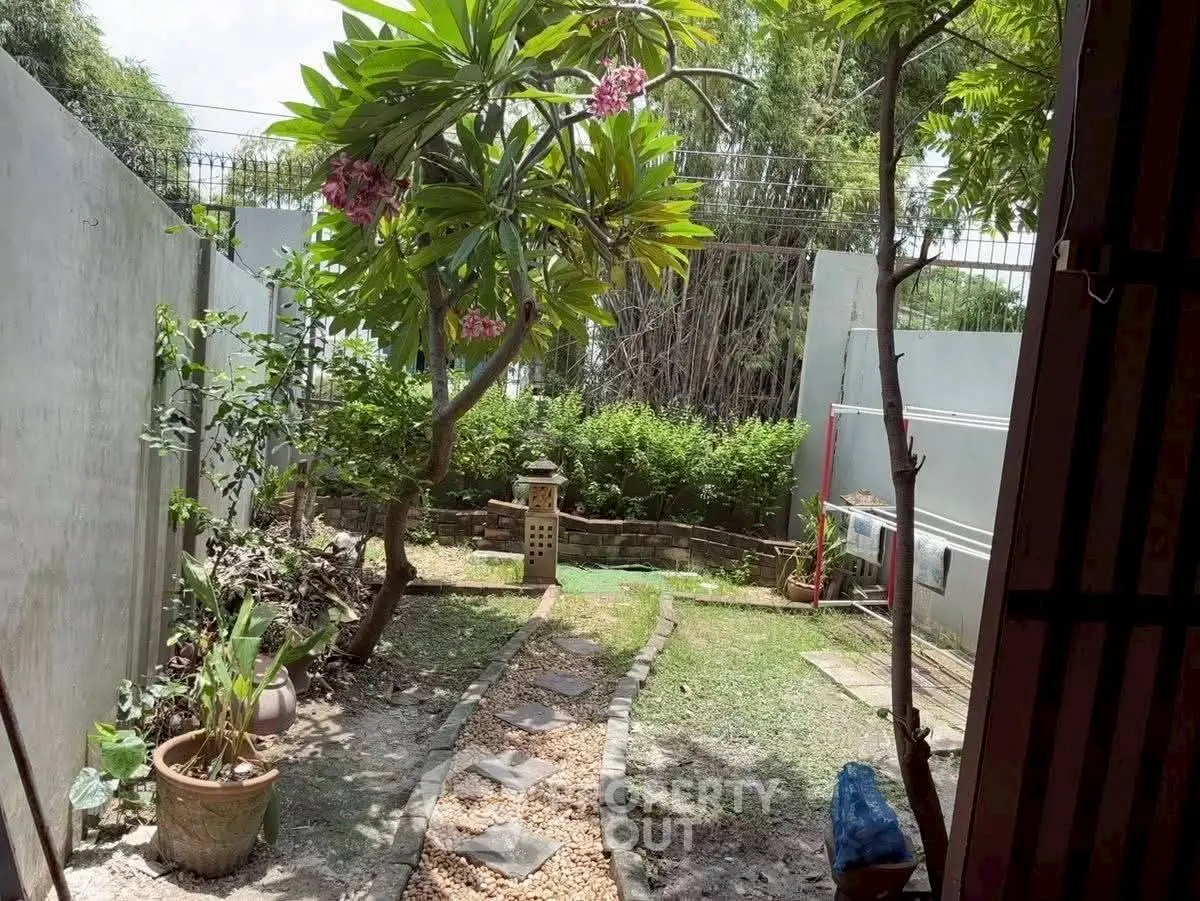 Charming garden view with lush greenery and stone pathway, perfect for relaxation and outdoor enjoyment.