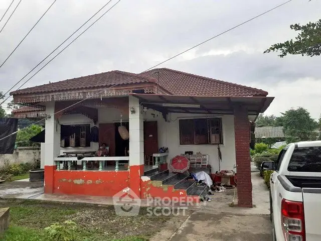 Charming single-story house with red roof and spacious front porch