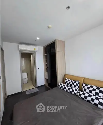 Modern bedroom with ensuite bathroom and stylish decor in a contemporary apartment.