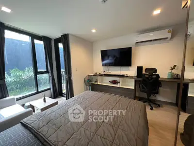 Modern bedroom with large window, stylish decor, and workspace, perfect for urban living.