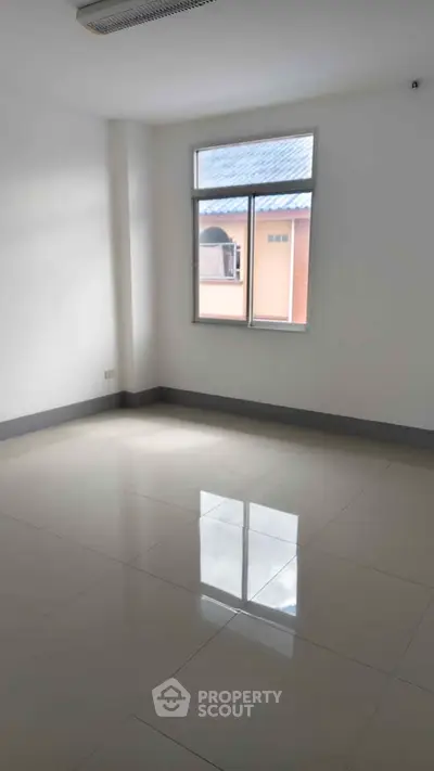 Spacious empty room with large window and glossy tiled floor, perfect for customization.