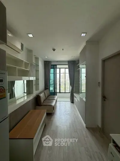 Modern living room with sleek design and large windows offering city views.