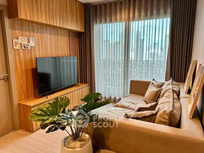 Modern living room with cozy sofa, large TV, and city view through floor-to-ceiling windows.