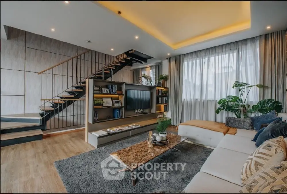 Luxurious modern living room with stylish staircase and cozy seating area.