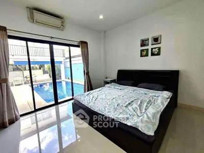 Spacious bedroom with pool view and modern decor in luxury home