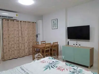 Cozy living room with modern decor, featuring a wall-mounted TV, dining table, and air conditioning.
