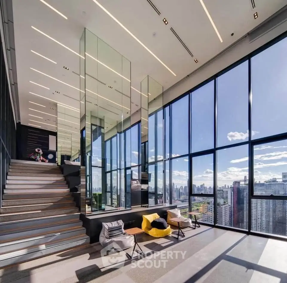 Luxurious modern living room with floor-to-ceiling windows offering stunning city views and elegant decor.