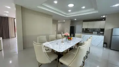 Elegant dining area with marble table and modern kitchen in open layout apartment