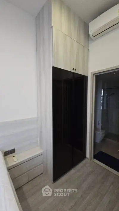 Modern bedroom with sleek wardrobe and air conditioning unit