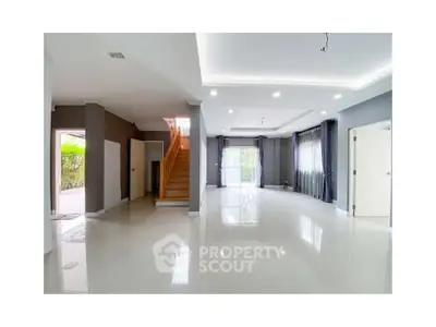 Spacious modern living room with glossy floors and elegant staircase