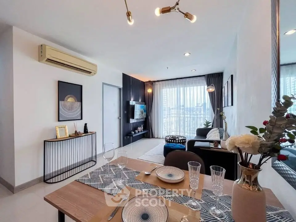 Modern living room with stylish decor and dining area, featuring large windows and elegant lighting.