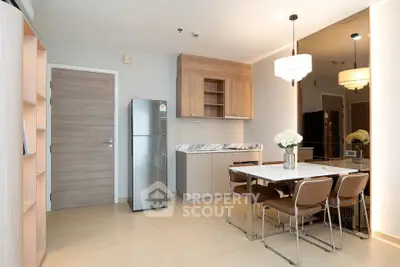 Modern dining area with wooden accents and stainless steel fridge in open layout kitchen.