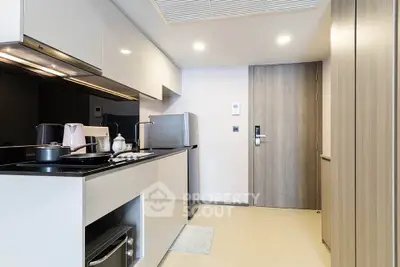 Modern kitchen with sleek cabinetry and stainless steel appliances in a stylish apartment.