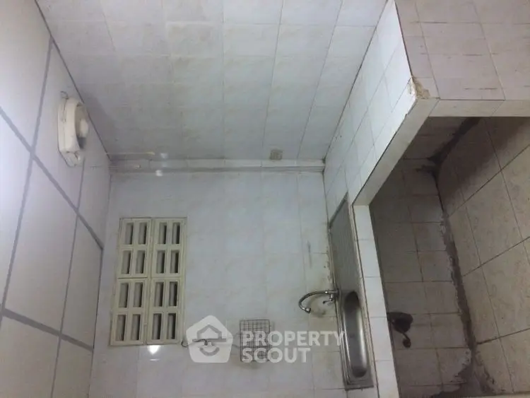 Compact kitchen with tiled walls and small sink, ideal for minimalist living.