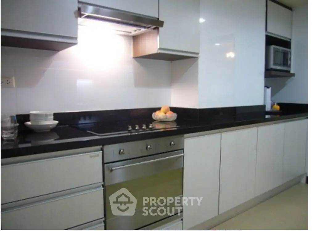 Modern kitchen with sleek cabinetry and built-in oven, perfect for culinary enthusiasts.