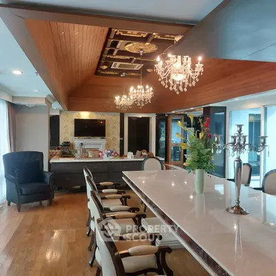 Luxurious dining room with elegant chandeliers and a spacious marble table.