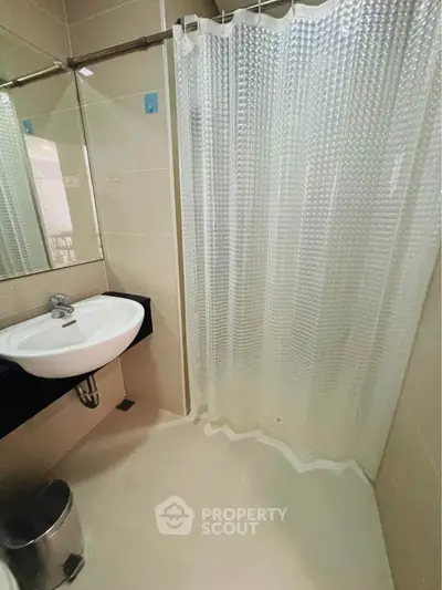 Modern bathroom with sleek sink and shower curtain in contemporary apartment.