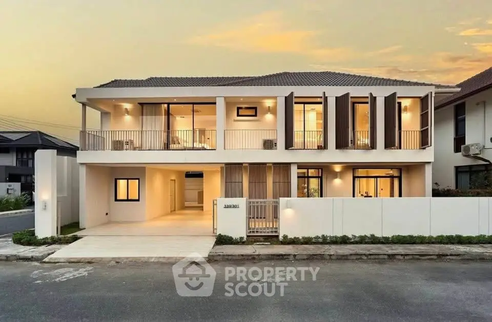 Stunning modern two-story house with elegant facade and spacious balcony at sunset.