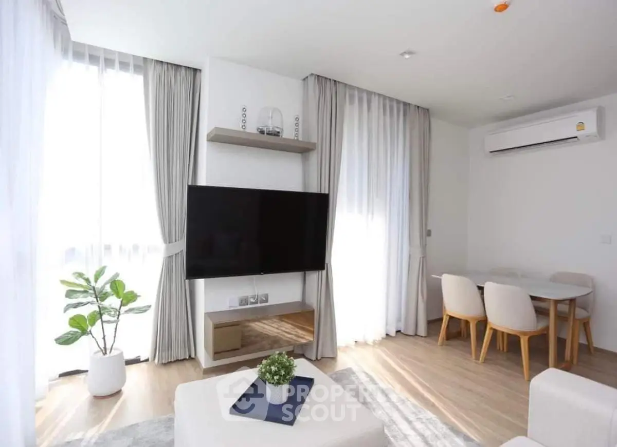 Modern living room with natural light, stylish furniture, and sleek decor